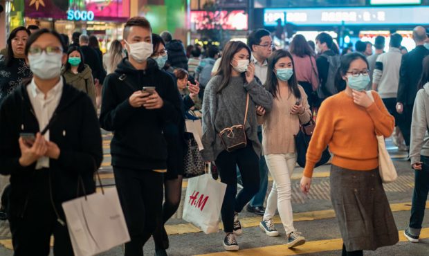 HONG KONG, CHINA - JANUARY 23: Pedestrians wear face masks as they walk through a crosswalk in Caus...