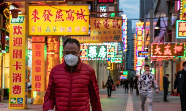 Residents wearing face masks walk on a street on January 28, 2020 in Macau, China. The number of ca...