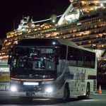 A bus carrying passengers who will take the flight chartered by the government of the Hong Kong Special Administrative Region of the People's Republic of China drives past the quarantined Diamond Princess cruise ship docked at the Daikoku Pier on February 19, 2020 in Yokohama, Japan. About 500 passengers who have tested negative for the coronavirus (COVID-19) were allowed to disembark the cruise ship on Wednesday after 14 days quarantine period as at least 542 passengers and crew onboard have tested positive for the coronavirus. Including cases onboard the ship, 615 people in Japan have now been diagnosed with COVID-19 making it the worst affected country outside of China.  (Photo by Tomohiro Ohsumi/Getty Images)