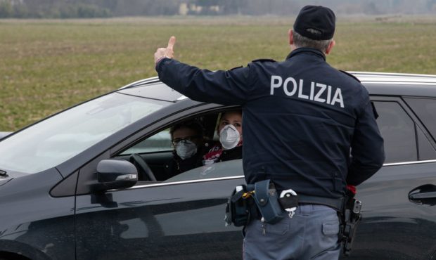 CASALPUSTERLENGO, ITALY - FEBRUARY 23: An Italian National Police officer talks to a driver in a ca...