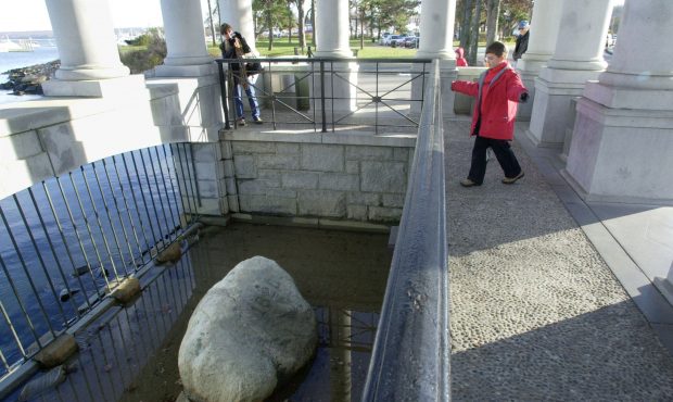 PLYMOUTH, MA - NOVEMBER 25:  Visitors look over a railing at Plymouth Rock, which according to trad...