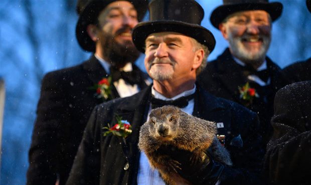 Groundhog handler John Griffiths holds Punxsutawney Phil, who did not see his shadow, predicting an...