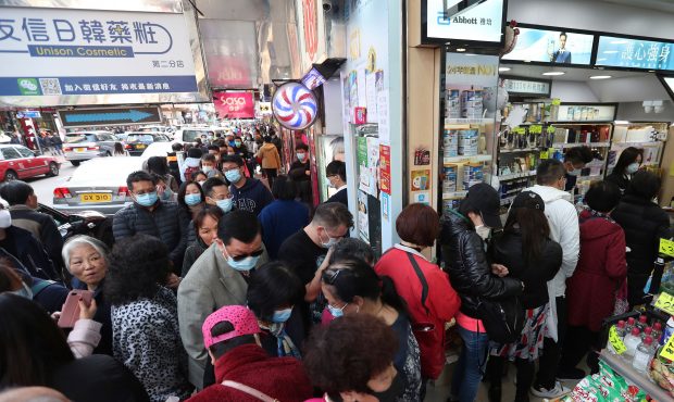 People queue for free face masks outside a cosmetics shop at Tsuen Wan in Hong Kong, Tuesday, Jan 2...