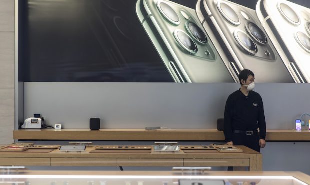 A security guard wearing a protective mask stands guard inside an Apple Inc. store in Shanghai, Chi...