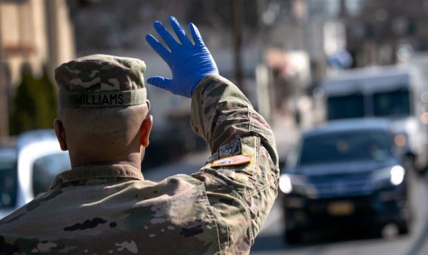 A U.S. National Guard soldier stops traffic as fellow troops distribute food to local residents at ...