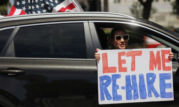 A demonstrator participates in a car caravan protest outside City Hall calling on California offici...