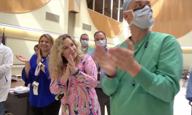A line of staff members and medical center leadership cheered their first Covid-19 patient on after...