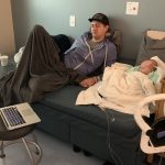 Casey Hendricks lays on a hospital bed with his little baby, Lettie.