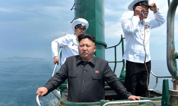 North Korean leader Kim Jong Un (front) stands on the conning tower of a submarine during his inspe...