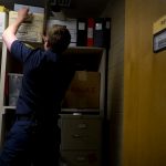 Captain Lyndsie Hauck reaches for a box in the Records Room at the South Salt Lake Fire Department.