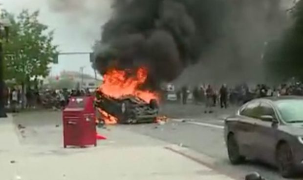 A man who pointed a bow and arrow at protesters had his car flipped and set on fire in Salt Lake Ci...