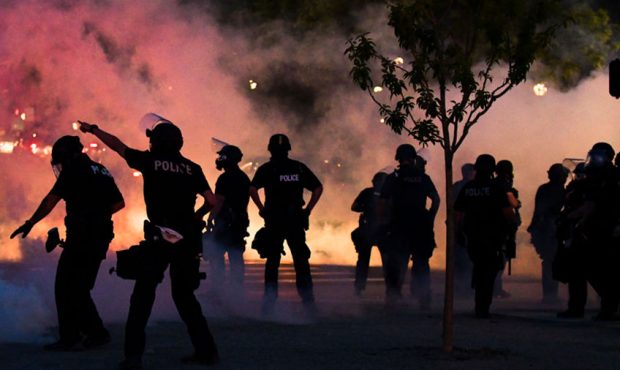 Police officers fire tear gas at protesters near the Colorado state capitol during a protest on May...