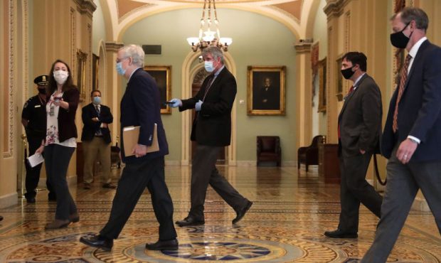 U.S. Senate Majority Leader Sen. Mitch McConnell (R-KY) wears a mask as he walks through a hallway ...