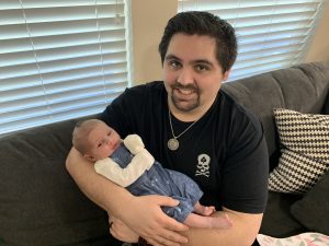 Matt Snow holding his new daughter at home.