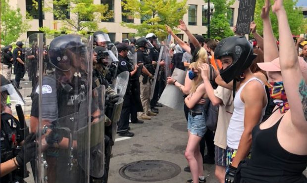 Protesters and police officers line a street in downtown Salt Lake City Saturday, May 30, 2020. (Sh...