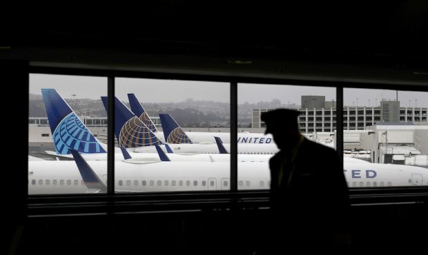 A pilot walks by United Airlines planes as they sit parked at gates at San Francisco International ...