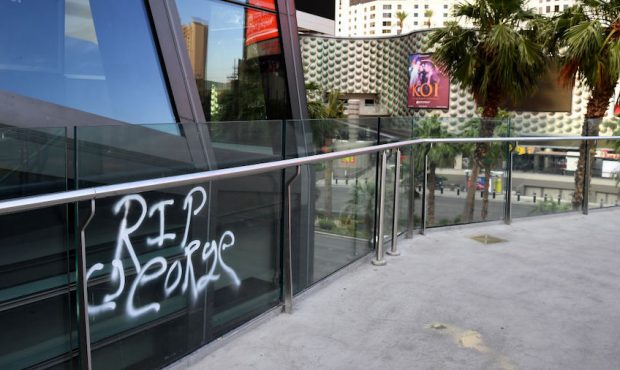 The words "RIP George" are spray painted onto the side of a pedestrian bridge next to The Cosmopoli...