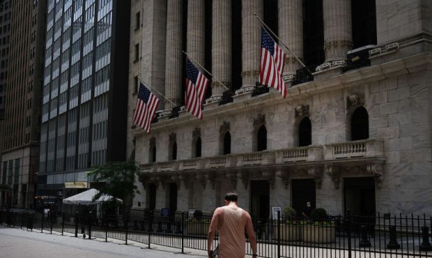 People walk by the New York Stock Exchange (NYSE) in an empty Financial District on June 15, 2020 i...