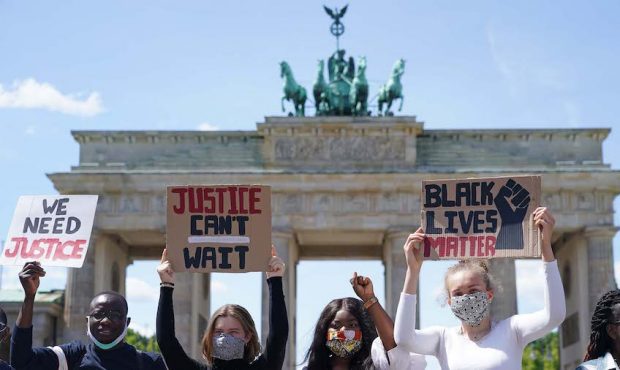 People attend a protest rally against racism in front of the Brandenburg Gate following the recent ...