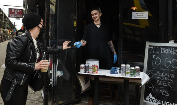 A bartender sells a frozen margarita to go to a customer in the Bushwick neighborhood on April 2, 2...