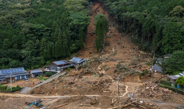 ASHIKITA, JAPAN - JULY 06: Houses lie submerged in mud after a landslide caused by torrential rain,...