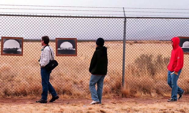 Tourists look at photographs of the first nuclear bomb test at the Trinity Site where the bomb was ...