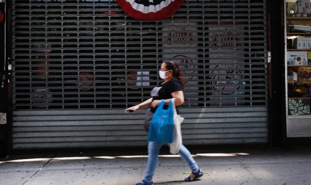 People walk by stores, many closed, along River Avenue near Yankee Stadium on July 23, 2020 in the ...