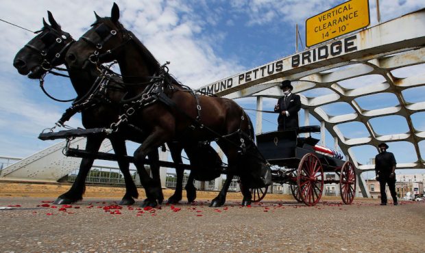 The casket of Rep. John Lewis moves over the Edmund Pettus Bridge by horse drawn carriage during a ...