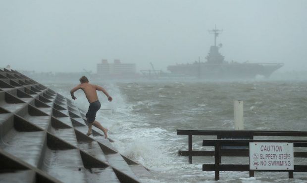 A man jumps from a wave as Hurricane Hanna begins to make landfall, Saturday, July 25, 2020, in Cor...