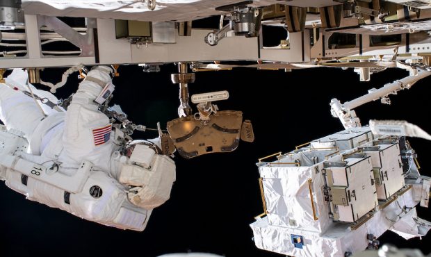 NASA astronaut Bob Behnken (at left) is pictured during a spacewalk to swap batteries and upgrade p...