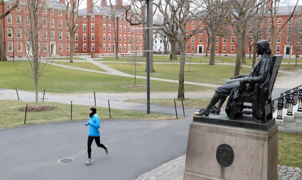 A runner crosses Harvard Yard on March 23, 2020 in Cambridge, Massachusetts. International students...