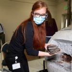Emiline Twitchell, a conservator at the Church History Library, removes time capsule items from the capstone of the Salt Lake Temple on May 20, 2020.
