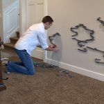 Stringham assembles a marble track on the wall.