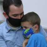 Scott Henslee held his 6-year-old son, Kaden, as he got his flu shot.