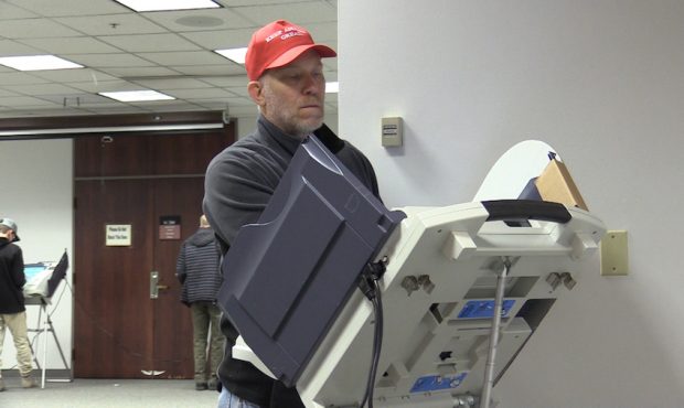 A man casts his ballot while wearing a political hat and no face mask in Salt Lake County. (KSL-TV)...