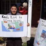 Kai and Junko Papenfuss hold their posters to Disneyland and Disneyworld. (KSL-TV)