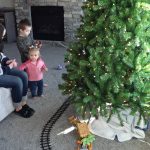 Kami Christensen helps her kids, Jed and McKenna, set up an electric train under their Christmas tree.