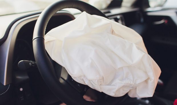 Interior of an automobile or car involved in a vehicle crash with a deployed steering column airbag...
