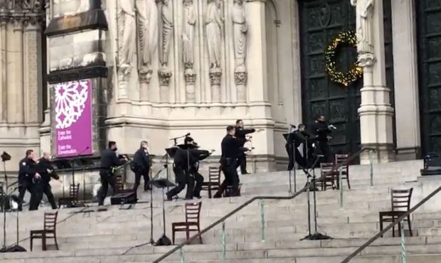 New York police officers move in on the scene of a shooting at the Cathedral Church of St. John the...