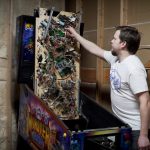 Kelly Thomson shows what the innards of a pinball machine look like.