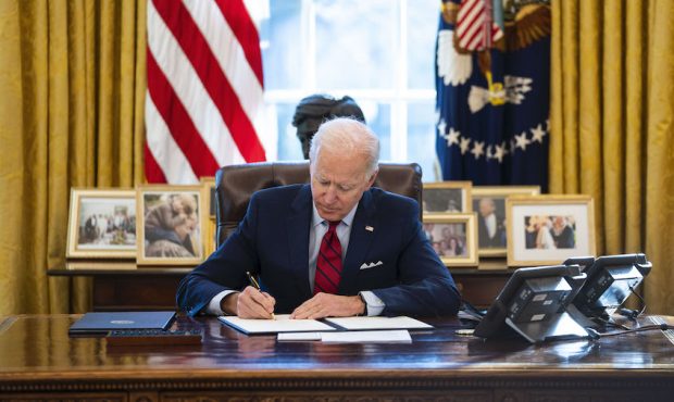 U.S. President Joe Biden signs executive actions in the Oval Office of the White House on January 2...