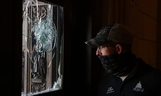 A member of the Architect of the Capitol inspects a damaged entrance of the U.S. Capitol January 7,...