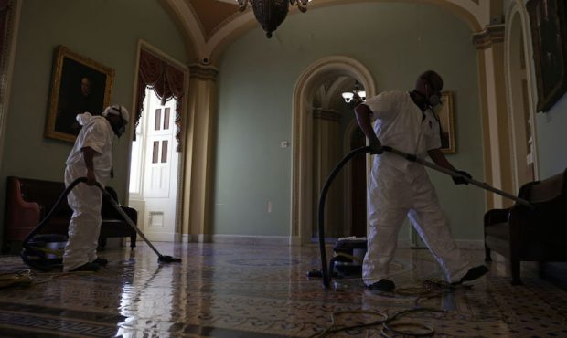 A cleaning crew vacuums the floor of a hallway at the U.S. Capitol January 7, 2021 in Washington, D...
