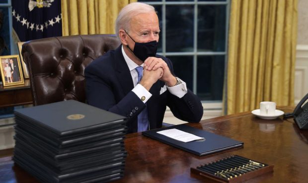 U.S. President Joe Biden prepares to sign a series of executive orders at the Resolute Desk in the ...