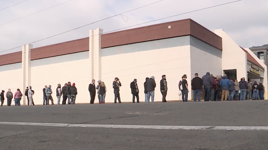 Hundreds of people stand outside the gun shop in Orem