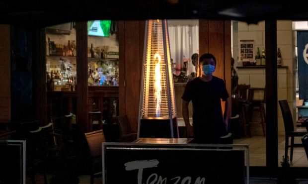 A waiter wearing a mask stands near a heater at Tenzan's outdoor dining on October 18, 2020 in New ...