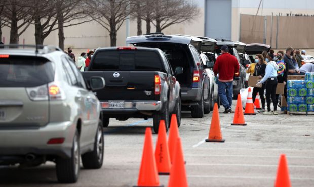 Volunteers load food into cars during the Houston Food Bank food distribution at NRG Stadium on Feb...
