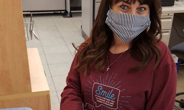 An employee in a Utah driver license office wears a shirt that promotes signing up to be an organ d...