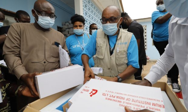 UNICEF staff examine a box containing the first shipment of COVID-19 vaccines distributed by the CO...