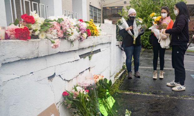 Mourners visit and leave flowers at the site of two shootings at spas across the street from one an...